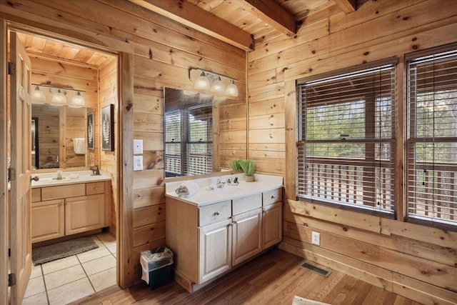 bathroom with beamed ceiling, a healthy amount of sunlight, wood ceiling, and wooden walls