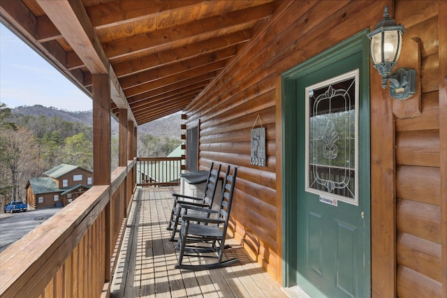 deck featuring a mountain view and covered porch