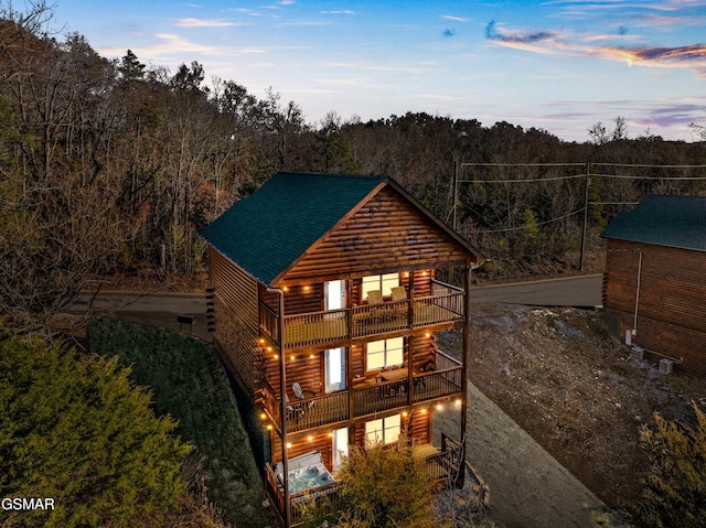 exterior space with a balcony and a forest view