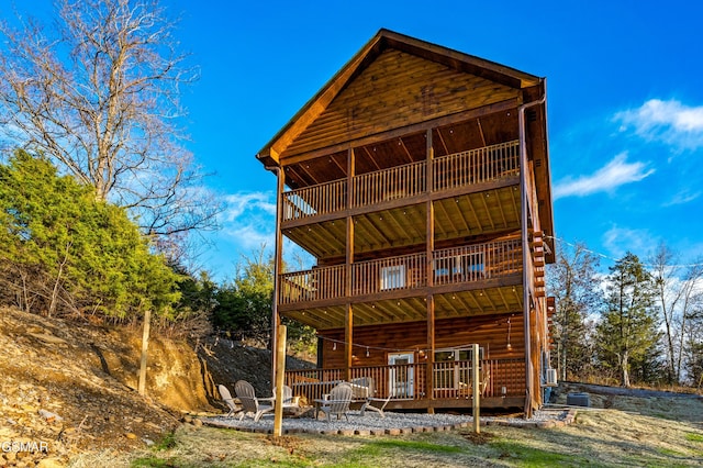 rear view of property featuring an outdoor fire pit, a wooden deck, and central AC unit