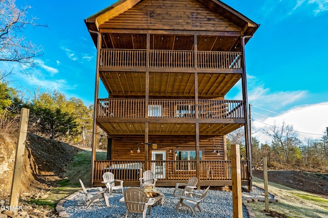 back of house with an outdoor fire pit and a wooden deck