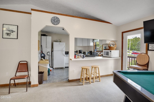 1081 Cove Rd Unit 612, Sevierville, TN 37876 - kitchen featuring white appliances, lofted ceiling, carpet floors, a kitchen breakfast bar, and baseboards