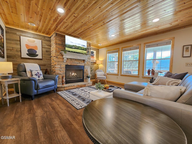 living room featuring recessed lighting, a stone fireplace, wood walls, wood ceiling, and dark wood-style flooring