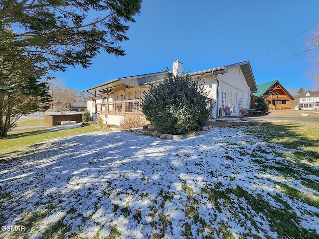 back of property with french doors, a chimney, and a hot tub