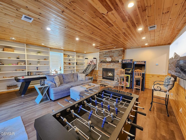 recreation room featuring built in shelves, wood finished floors, wooden ceiling, wainscoting, and wood walls