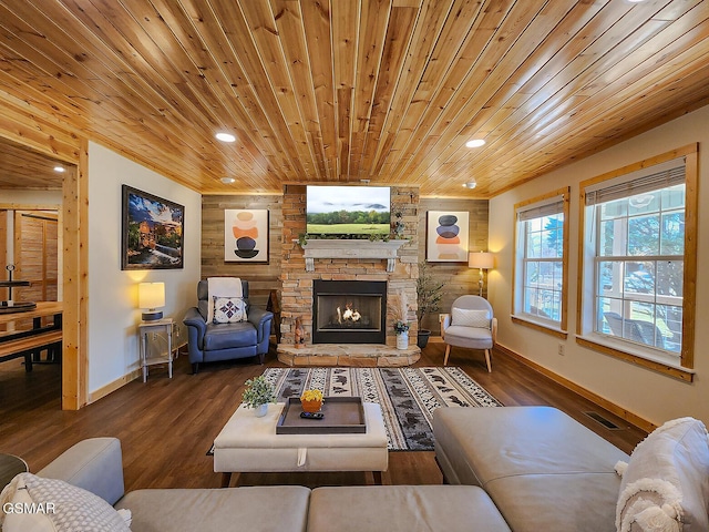 living area featuring a stone fireplace, wooden ceiling, visible vents, and wood finished floors