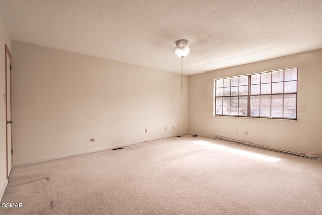carpeted spare room with a textured ceiling