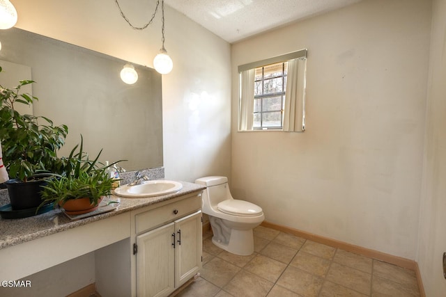 half bathroom featuring baseboards, toilet, vanity, and a textured ceiling