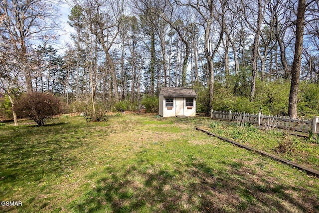 view of yard with an outbuilding, a storage unit, and fence