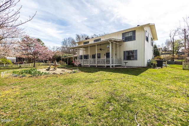 back of property featuring a yard and a ceiling fan