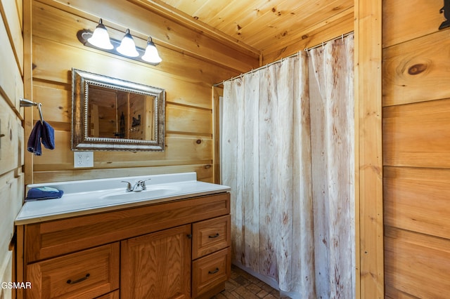 bathroom featuring wood walls, wood ceiling, brick floor, and vanity