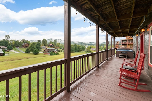 wooden deck featuring a yard and a hot tub