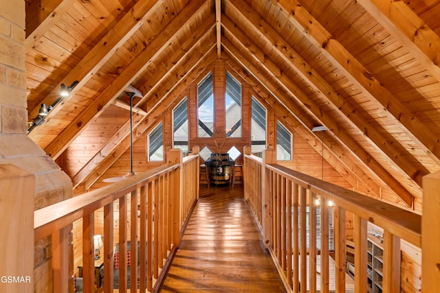 corridor with lofted ceiling with beams, wooden walls, and wooden ceiling