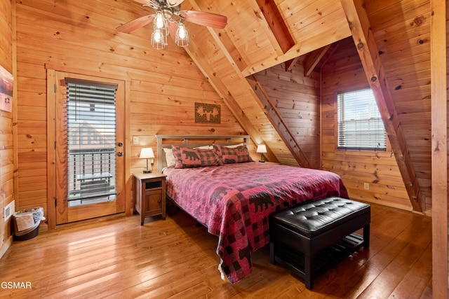 bedroom featuring hardwood / wood-style floors, access to exterior, wood ceiling, and wooden walls