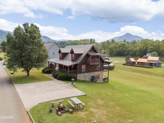 view of front of home with a mountain view and a front lawn