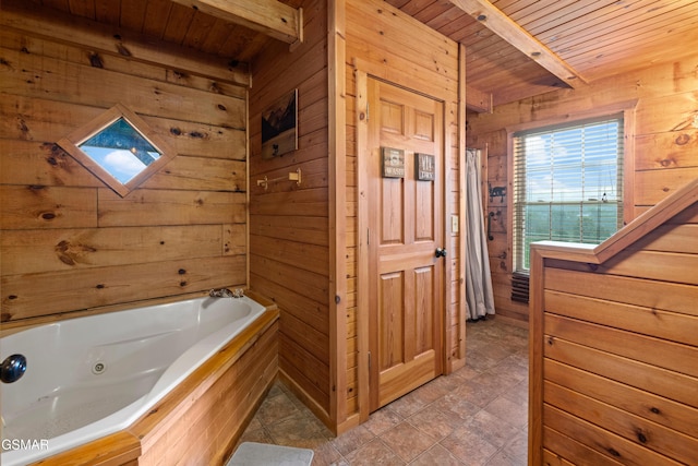 bathroom with beam ceiling, wood ceiling, a tub, and wooden walls