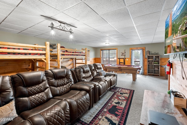 carpeted living room featuring a paneled ceiling, wood walls, and billiards