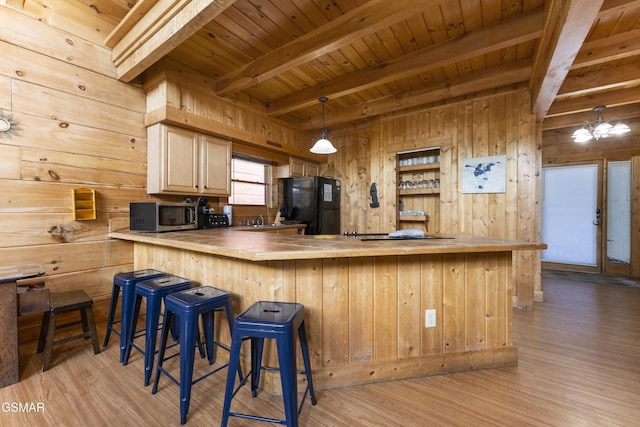 1251 Bear Cub Way, Gatlinburg, TN 37738 - kitchen featuring stainless steel microwave, freestanding refrigerator, light wood-style floors, beamed ceiling, and wood walls