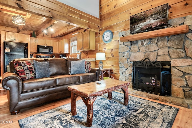 2904 Peregrine Way, Pigeon Forge, TN 37863 - living area with light wood-style floors, a wooden ceiling with exposed beams, wooden walls, and a stone fireplace