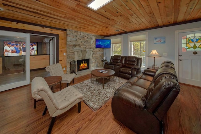 living area featuring wood finished floors, a stone fireplace, and wooden ceiling