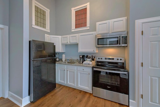 kitchen with white cabinetry, appliances with stainless steel finishes, and a sink