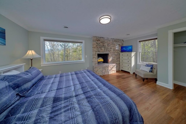bedroom with visible vents, multiple windows, wood finished floors, and ornamental molding