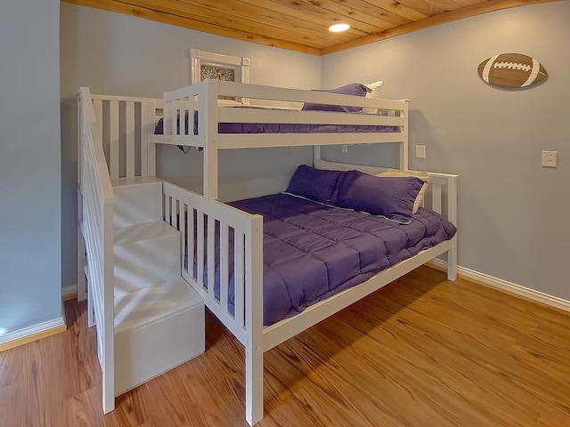 bedroom with wood ceiling, wood finished floors, and baseboards