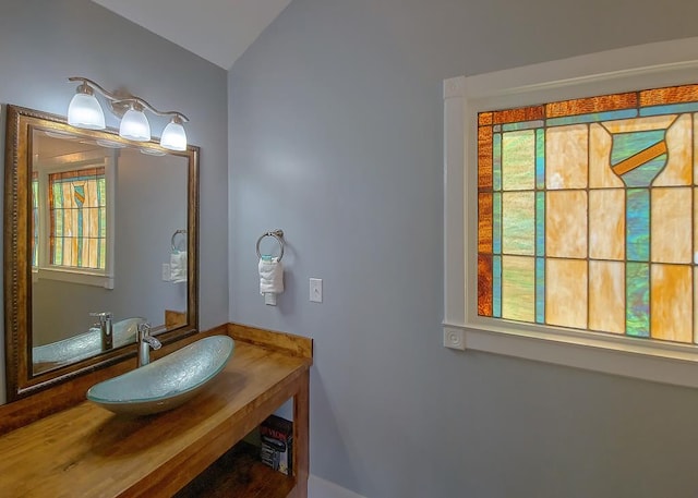 bathroom featuring a sink and vaulted ceiling