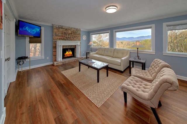 living area featuring a wealth of natural light, crown molding, and wood finished floors
