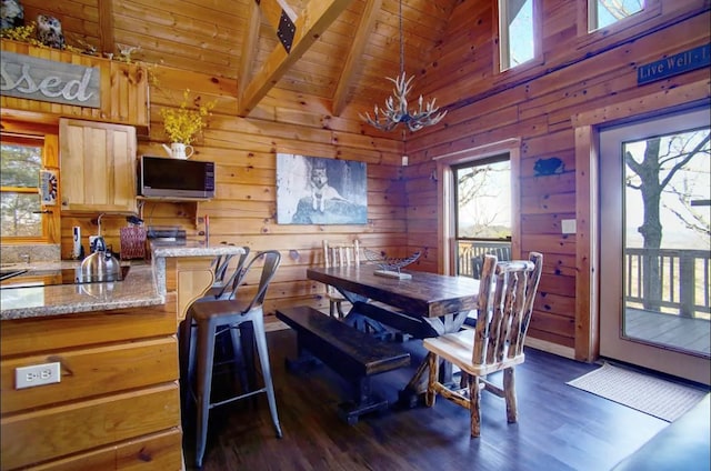 3831 Glenview Way, Sevierville, TN 37862 - dining space with a chandelier, dark wood-style floors, wooden walls, a wood ceiling with exposed beams, and high vaulted ceiling