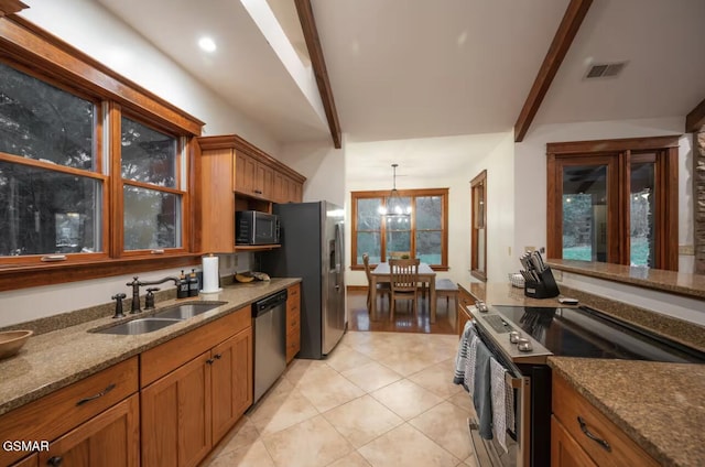 kitchen with stone countertops, decorative light fixtures, beamed ceiling, sink, and stainless steel appliances