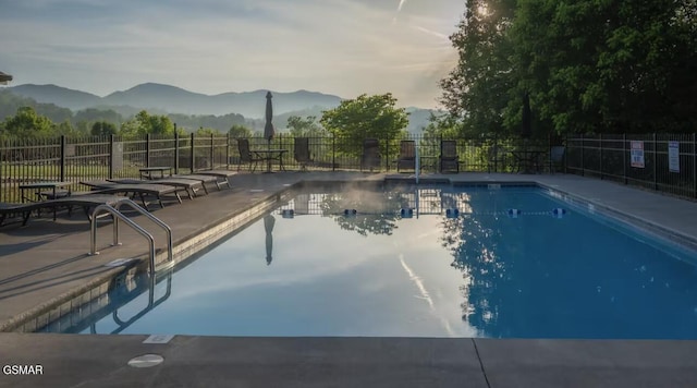 view of pool featuring a mountain view and a patio