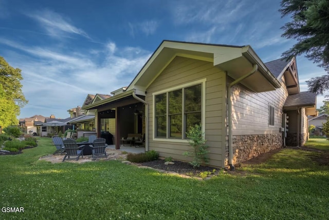 rear view of property featuring a patio and a lawn