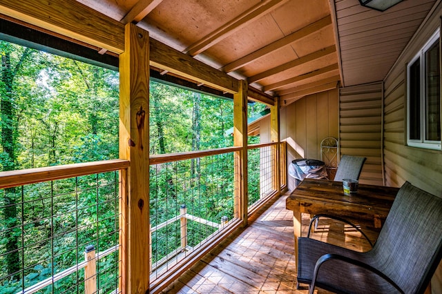 unfurnished sunroom featuring beamed ceiling and wood ceiling