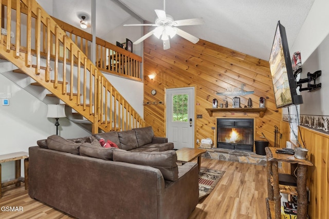 2108 Redmond Way, Sevierville, TN 37876 - living area featuring wooden walls, a fireplace, a ceiling fan, stairs, and wood finished floors