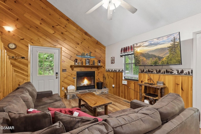 2108 Redmond Way, Sevierville, TN 37876 - living room with wood finished floors, wood walls, a stone fireplace, ceiling fan, and lofted ceiling