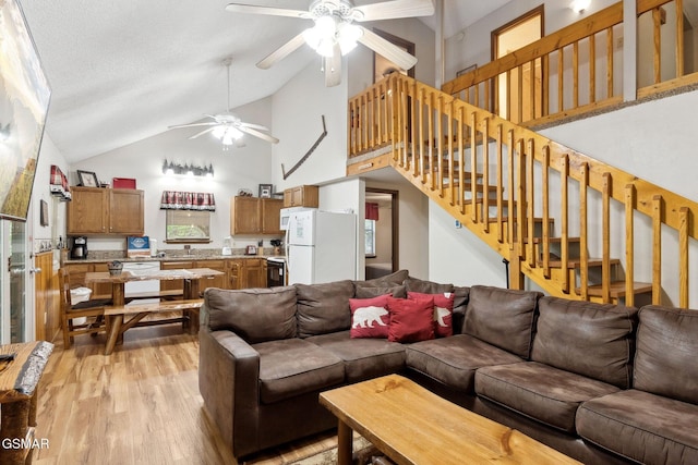 2108 Redmond Way, Sevierville, TN 37876 - living area featuring a ceiling fan, light wood-style flooring, stairs, and high vaulted ceiling
