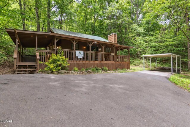 2108 Redmond Way, Sevierville, TN 37876 - rustic home with a chimney, driveway, covered porch, metal roof, and a detached carport