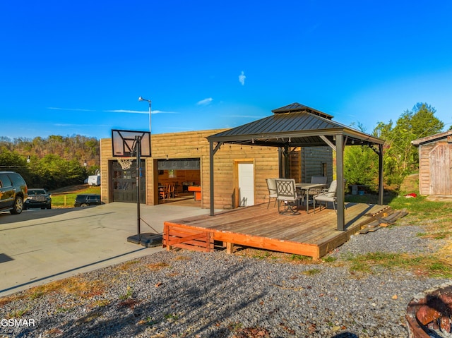 exterior space with a gazebo, a shed, and a wooden deck