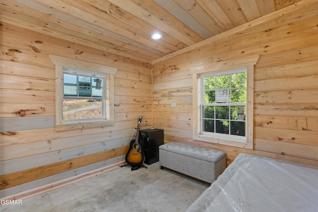 bedroom with wood ceiling, wood walls, and concrete floors