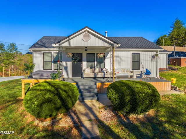 view of front of house featuring ceiling fan, covered porch, and a front yard