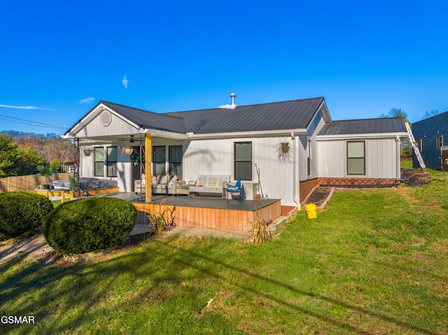 back of house featuring outdoor lounge area, ceiling fan, a yard, and a deck