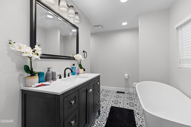 bathroom featuring a bathing tub, tile patterned flooring, and vanity