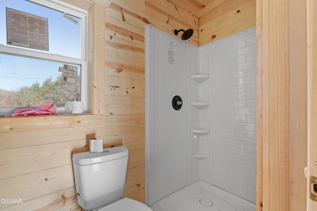 bathroom featuring walk in shower, wooden walls, and toilet