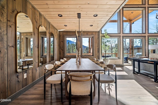 dining room featuring wooden ceiling, wood walls, a healthy amount of sunlight, and arched walkways