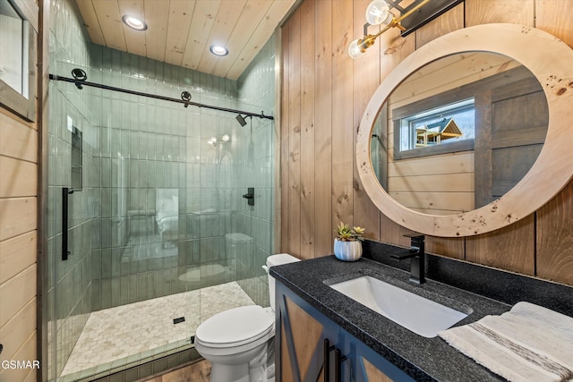 full bath with a stall shower, wooden walls, toilet, and vanity