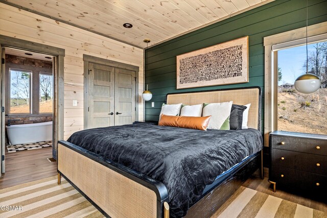 bedroom featuring wood ceiling, wooden walls, and wood finished floors