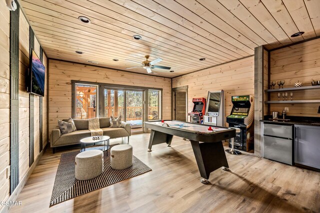 playroom featuring light wood-type flooring, wooden ceiling, wooden walls, and a community bar