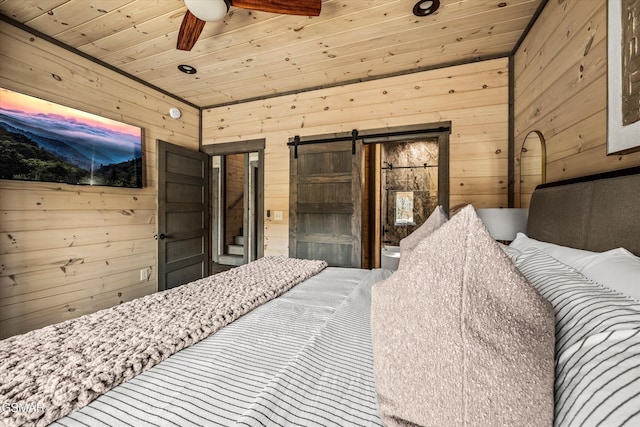 bedroom featuring wooden ceiling, a barn door, and wood walls