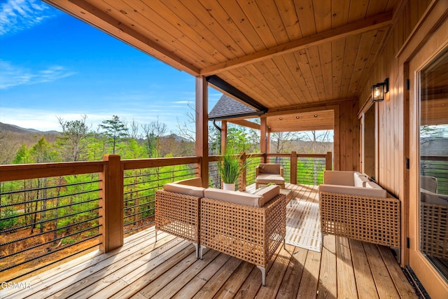 wooden deck with a mountain view and an outdoor hangout area